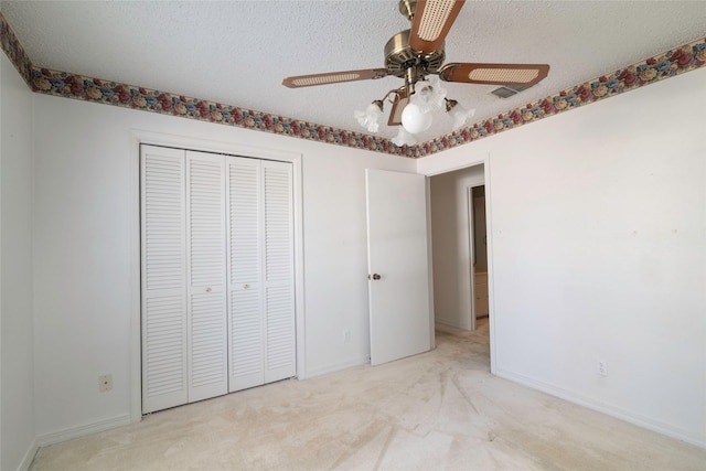 unfurnished bedroom with a closet, a textured ceiling, ceiling fan, and light carpet