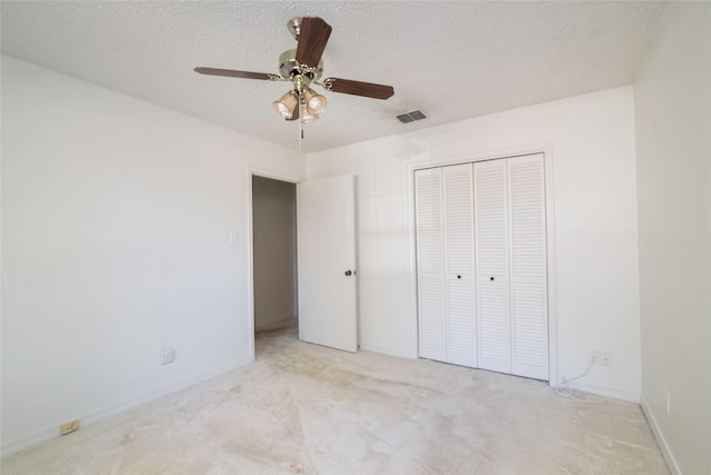 unfurnished bedroom featuring ceiling fan, a closet, and light carpet