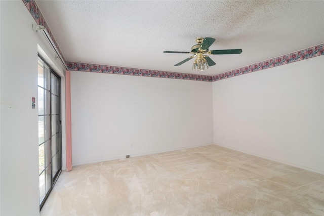 spare room with a textured ceiling, ceiling fan, a wealth of natural light, and light colored carpet