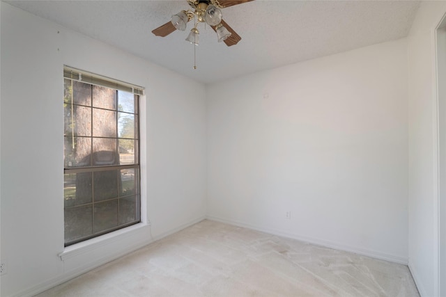 unfurnished room with light carpet, ceiling fan, and a textured ceiling