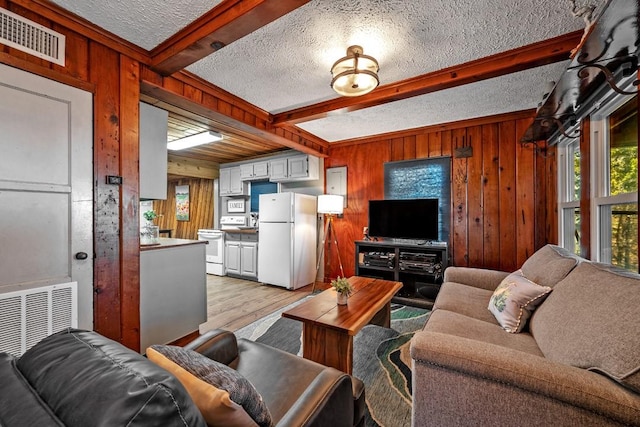 living room with beam ceiling and wood walls