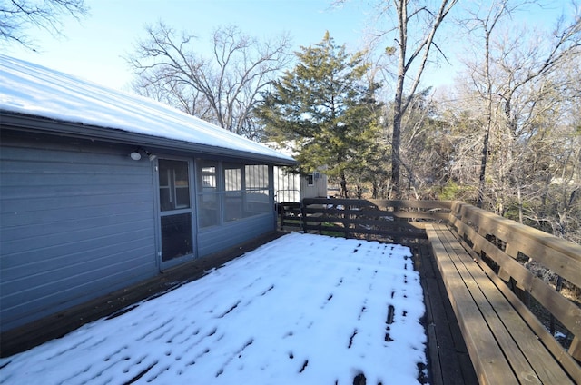 snow covered deck with a sunroom