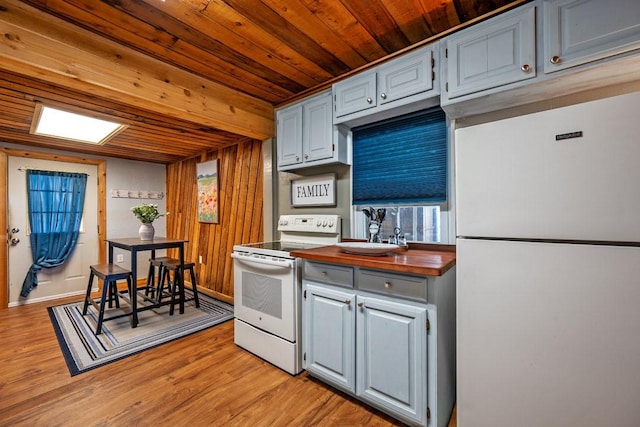 kitchen featuring white appliances, butcher block counters, wooden walls, wooden ceiling, and light wood-type flooring