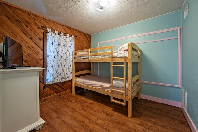 40 Zumwalt Cir, Pottsboro, TX 75076 - bedroom featuring a textured ceiling, wood finished floors, wooden walls, and baseboards