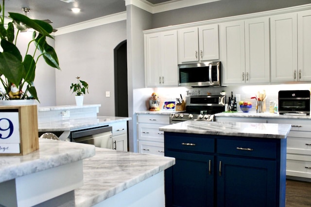 kitchen with white cabinets, light stone counters, ornamental molding, and appliances with stainless steel finishes