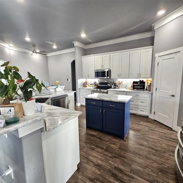 kitchen with white cabinets, stainless steel appliances, a spacious island, ornamental molding, and blue cabinets
