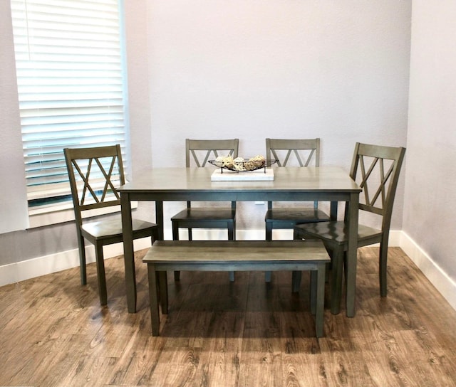 dining space featuring baseboards and wood finished floors