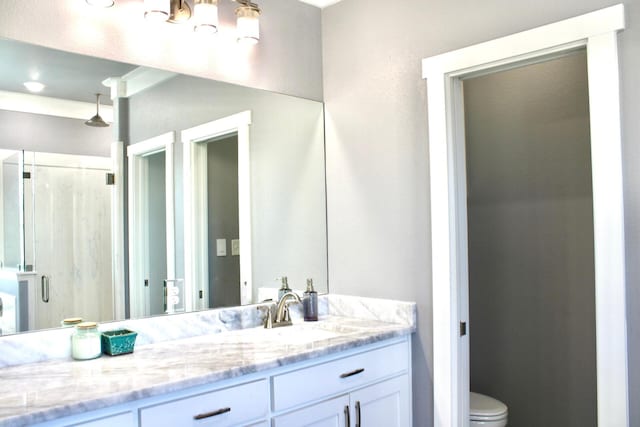 bathroom featuring toilet, a shower stall, and vanity