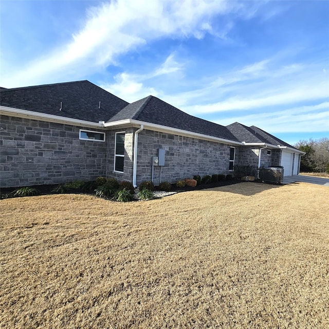 view of side of home featuring a garage and a yard