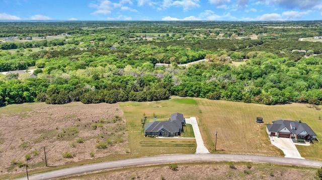 drone / aerial view featuring a wooded view