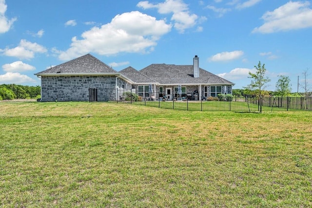 rear view of property featuring a lawn, a chimney, and fence private yard