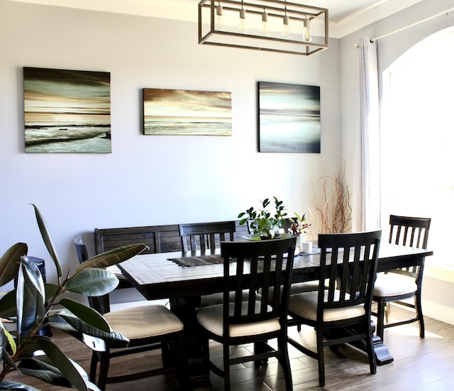 dining space featuring hardwood / wood-style floors and ornamental molding