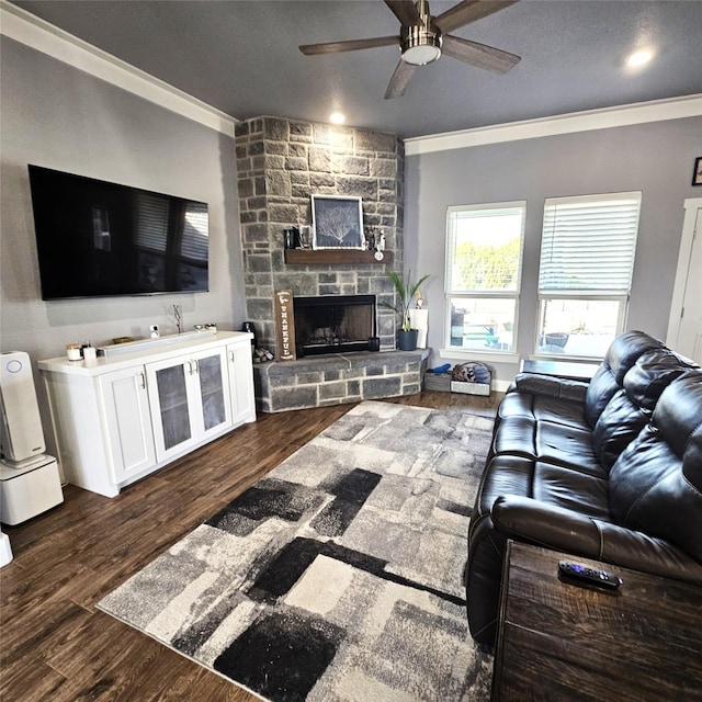 living room featuring ornamental molding, a fireplace, a ceiling fan, and dark wood-style floors