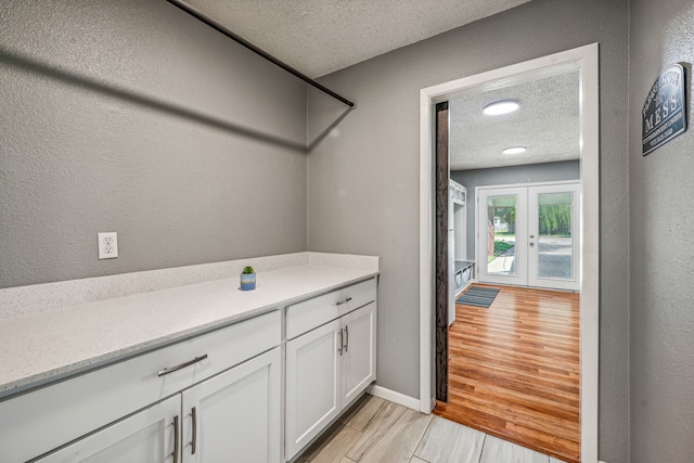 bathroom featuring vanity, french doors, and a textured ceiling