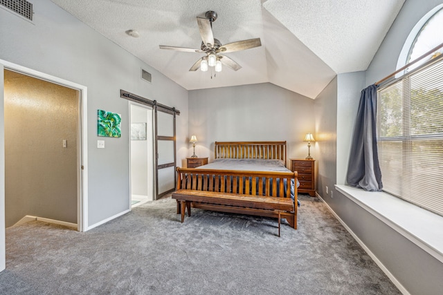 bedroom featuring carpet, ceiling fan, a barn door, and lofted ceiling