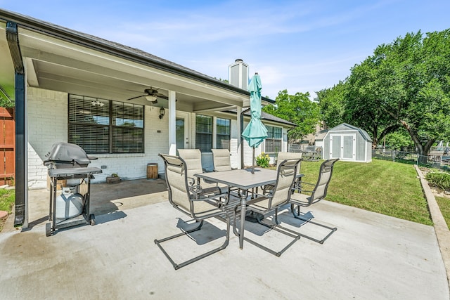 view of patio / terrace featuring ceiling fan, area for grilling, and a storage shed