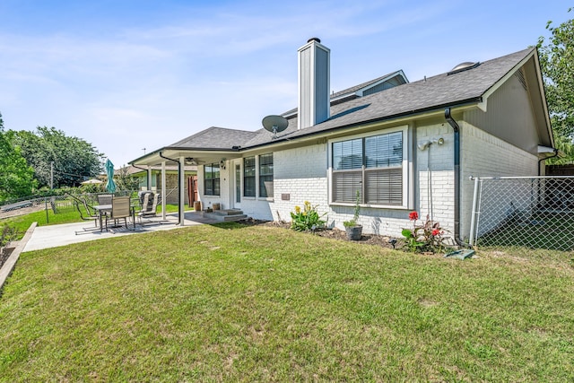 rear view of property with a yard and a patio