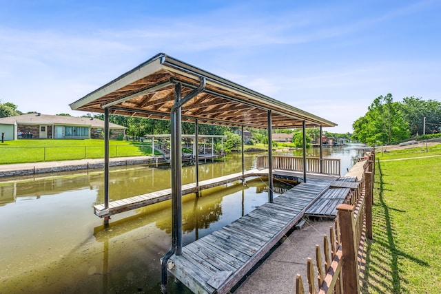 view of dock with a yard and a water view