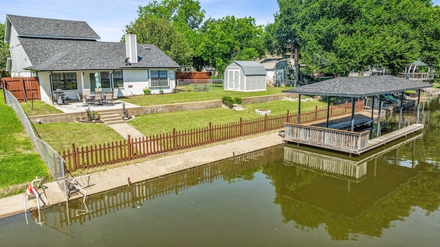 dock area featuring a patio area, a yard, and a water view