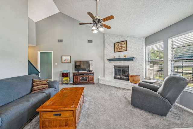 carpeted living room featuring a textured ceiling, high vaulted ceiling, a brick fireplace, and ceiling fan