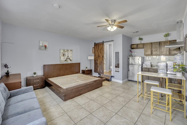 bedroom featuring ceiling fan, a barn door, light tile patterned flooring, and stainless steel refrigerator