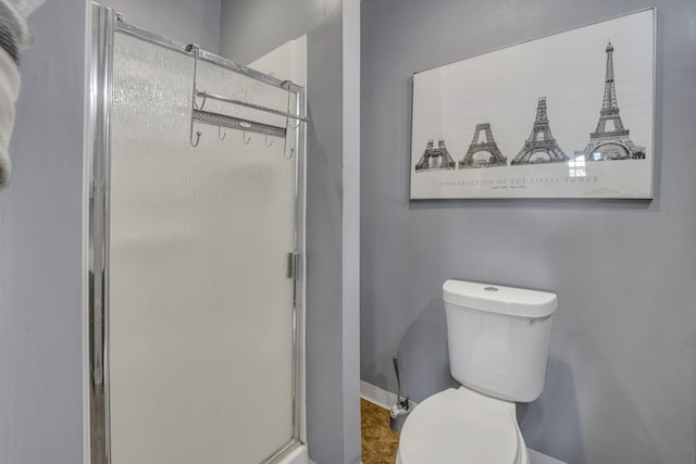 bathroom with toilet and a shower with shower door