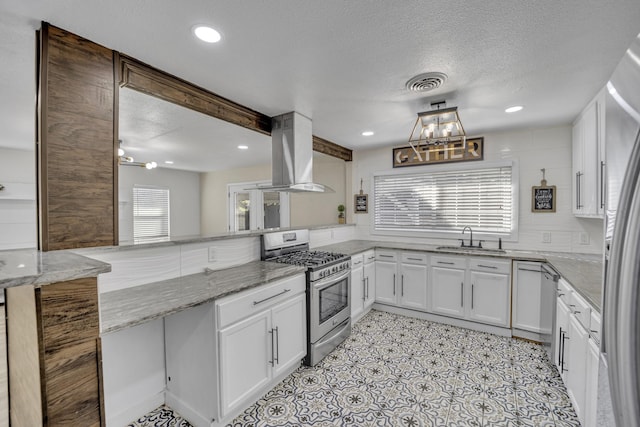 kitchen with light stone countertops, white cabinetry, kitchen peninsula, exhaust hood, and appliances with stainless steel finishes