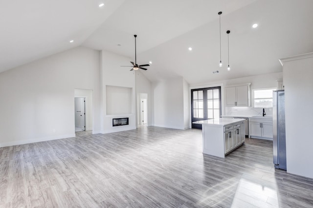 kitchen featuring ceiling fan, sink, decorative light fixtures, a kitchen island, and appliances with stainless steel finishes