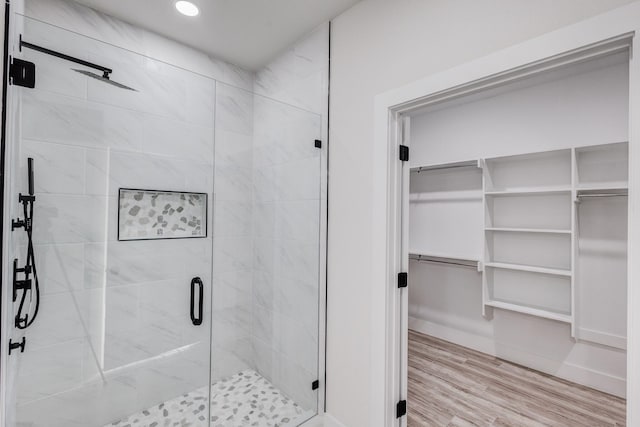 bathroom featuring hardwood / wood-style flooring and walk in shower