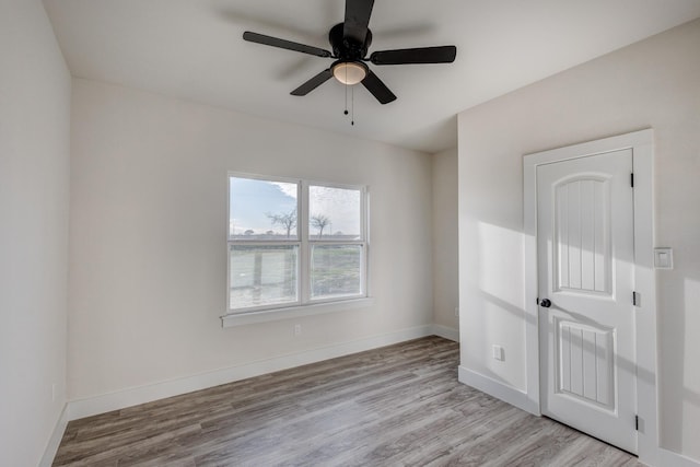 empty room with ceiling fan and light hardwood / wood-style flooring