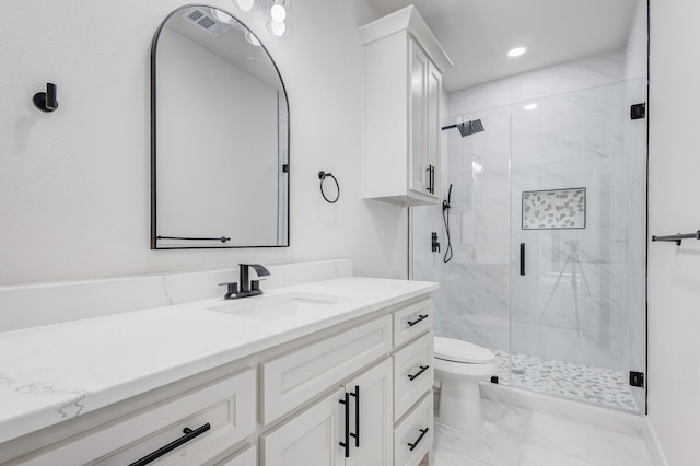 bathroom featuring an enclosed shower, vanity, and toilet