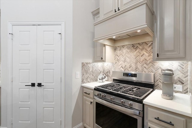 kitchen featuring gas range, premium range hood, and backsplash