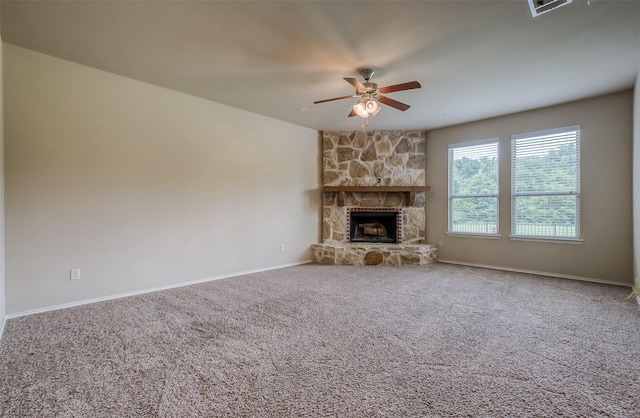 unfurnished living room featuring carpet flooring, a stone fireplace, and ceiling fan