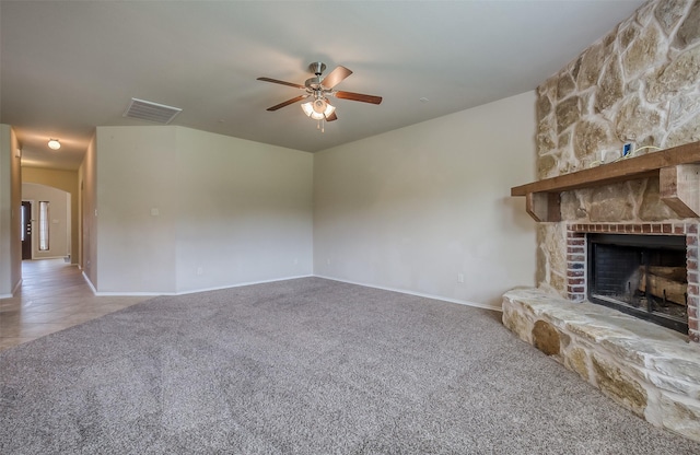 unfurnished living room with ceiling fan, carpet floors, and a fireplace