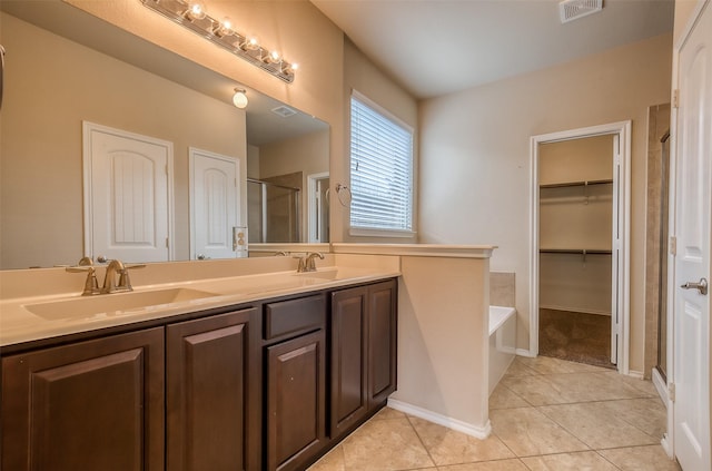 bathroom featuring tile patterned flooring, vanity, and shower with separate bathtub