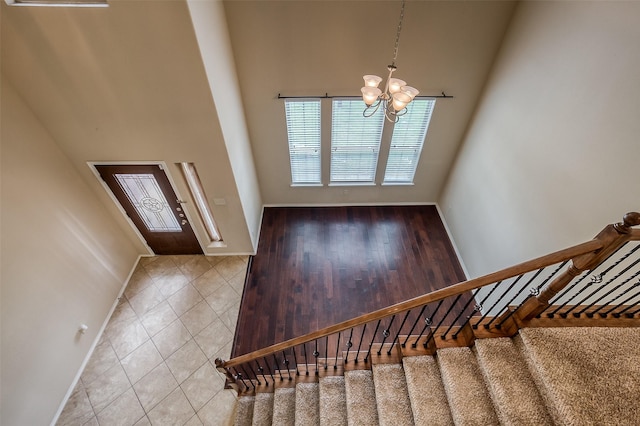 tiled foyer featuring a towering ceiling and a chandelier