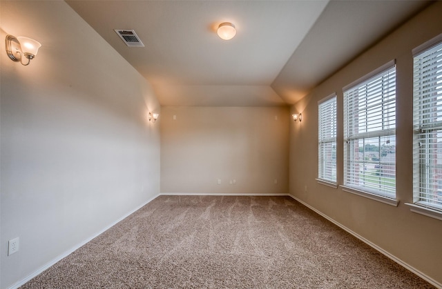 carpeted spare room with vaulted ceiling