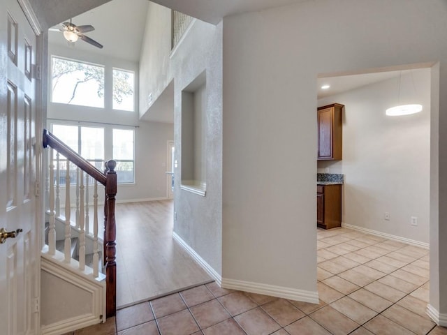 interior space featuring a towering ceiling and ceiling fan