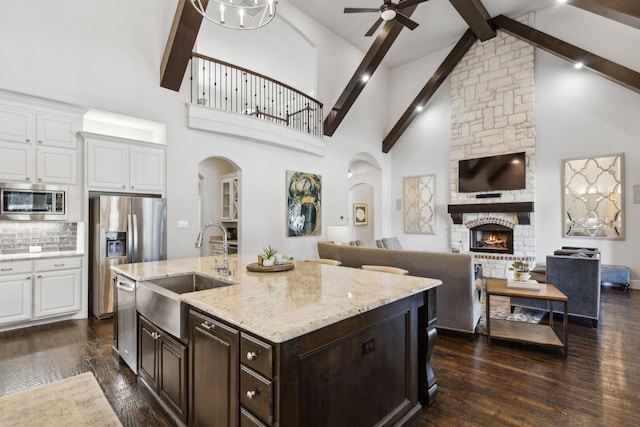 kitchen featuring sink, high vaulted ceiling, white cabinetry, and backsplash