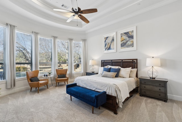 bedroom with multiple windows, ceiling fan, a tray ceiling, and light colored carpet