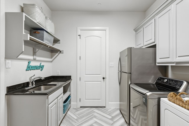 laundry area with light parquet flooring, independent washer and dryer, and sink