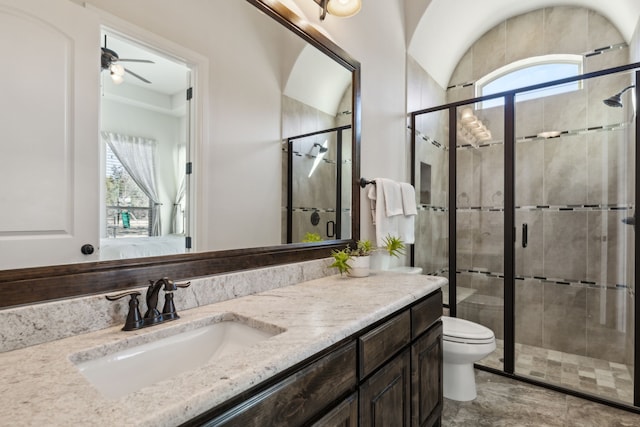 bathroom with toilet, an enclosed shower, vanity, and ceiling fan