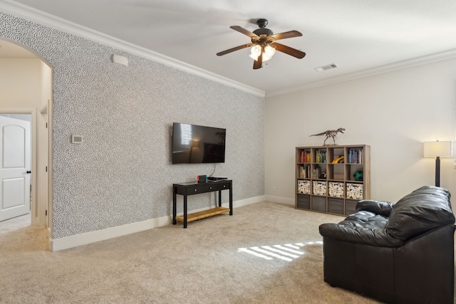 carpeted living room with ceiling fan and crown molding