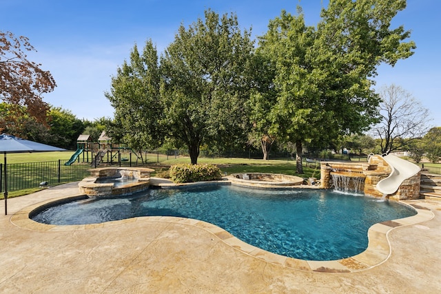 view of swimming pool featuring a water slide, a playground, an in ground hot tub, and pool water feature