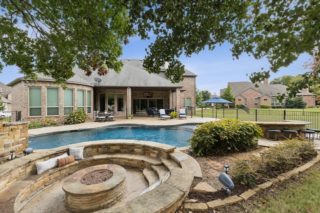 view of swimming pool featuring an outdoor fire pit and a patio