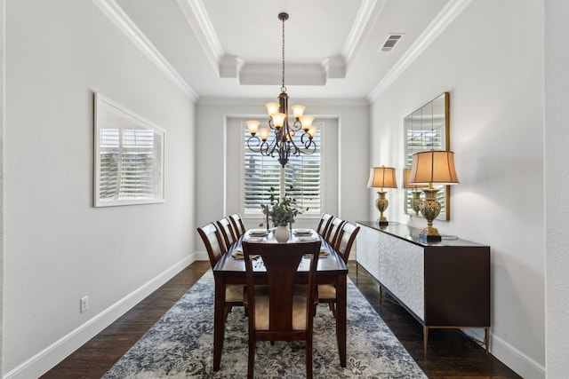 dining space featuring a chandelier, a healthy amount of sunlight, a tray ceiling, and ornamental molding