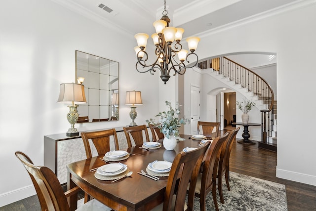 dining area with dark hardwood / wood-style flooring, a chandelier, and crown molding