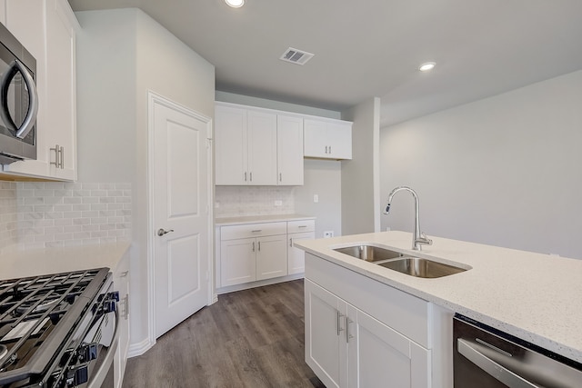 kitchen with backsplash, sink, white cabinetry, and stainless steel appliances