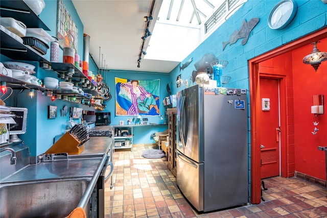 kitchen with stainless steel refrigerator, sink, and rail lighting