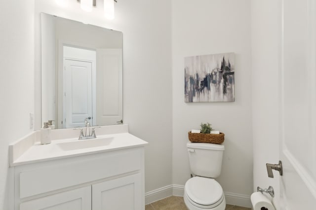 bathroom with toilet, tile patterned floors, and vanity